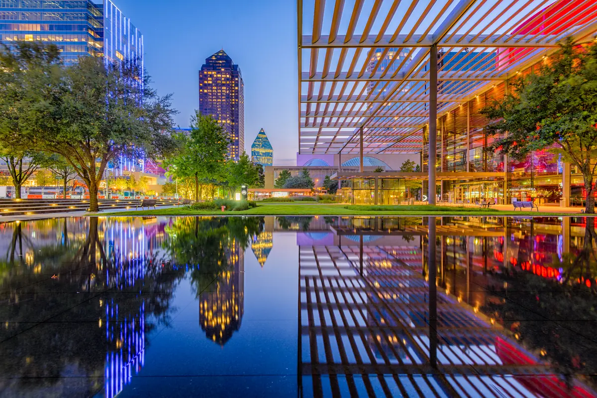 Downtown Dallas skyline at dusk reflected in a reflecting pool